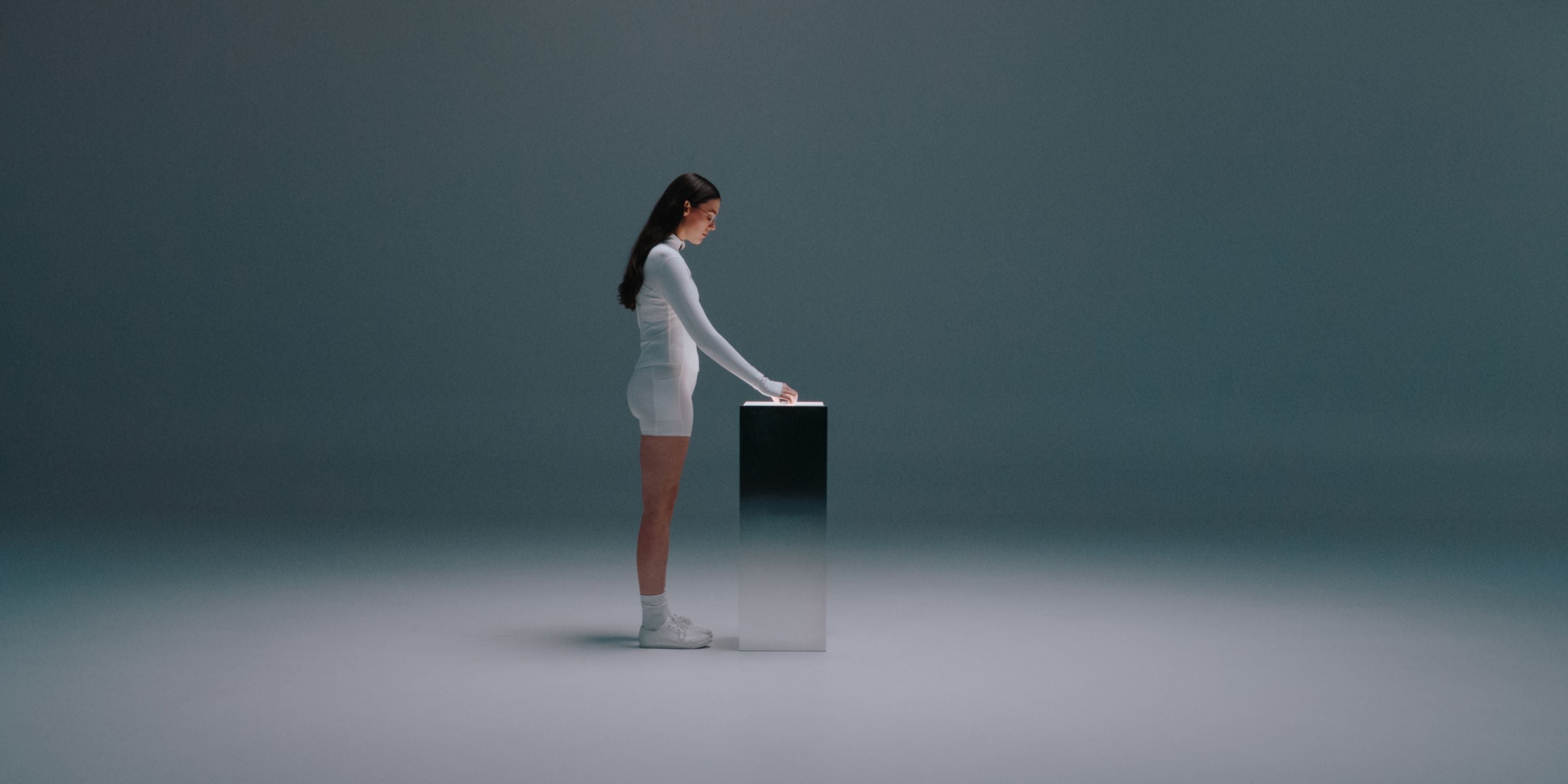Female picking up OTHERFRAME glasses from a metal podium [dark]