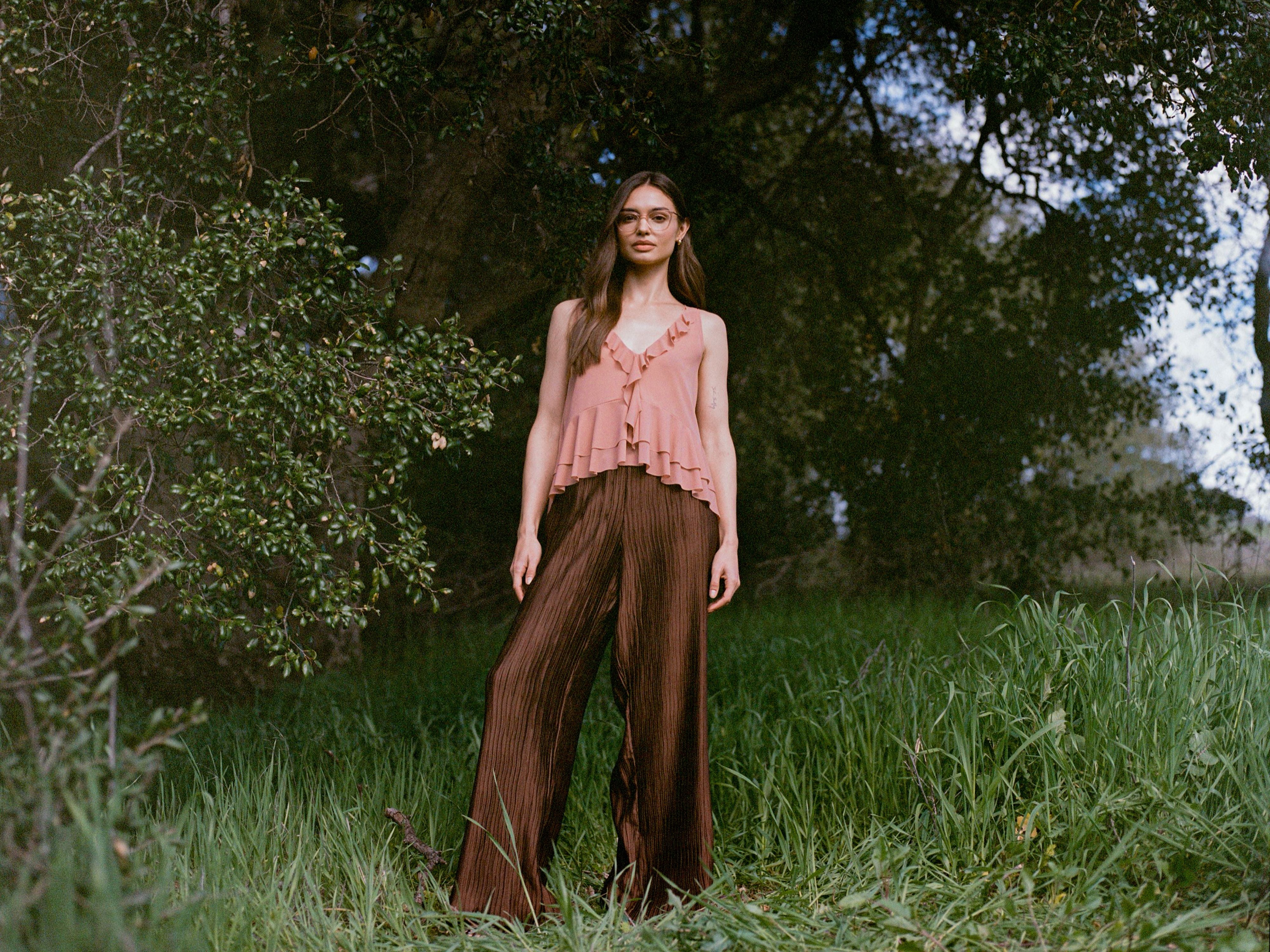 Female model standing on grass and looking at the camera [dark]